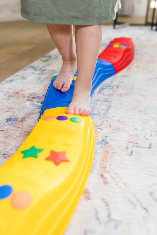 Preschool age child balancing while walking on balance beam, with Milestones at Play in the DFW metro
